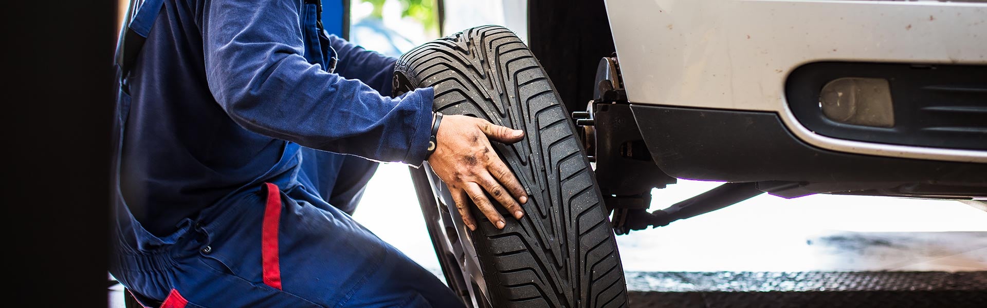 Service tech putting a tire on a car